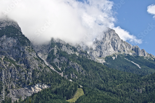 Rocky slope of a mountain partly covered by mist in the Tennen range in the Austrian Alps near the town of Werfen photo