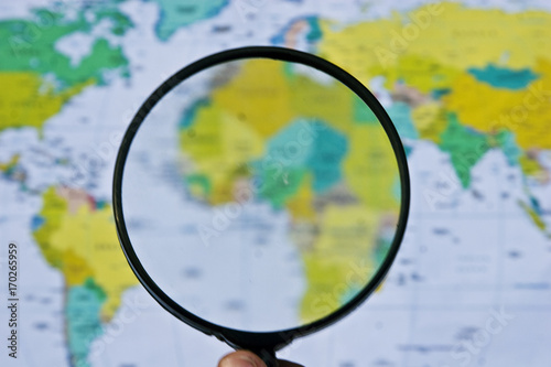 Magnifier on the background of a geographical map of the world from above