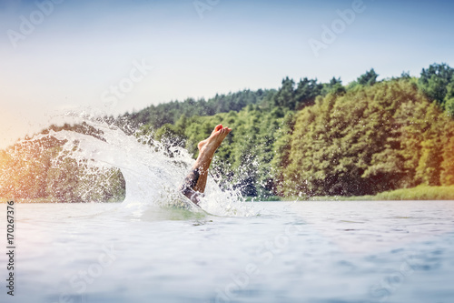 Young man diving into a lake.