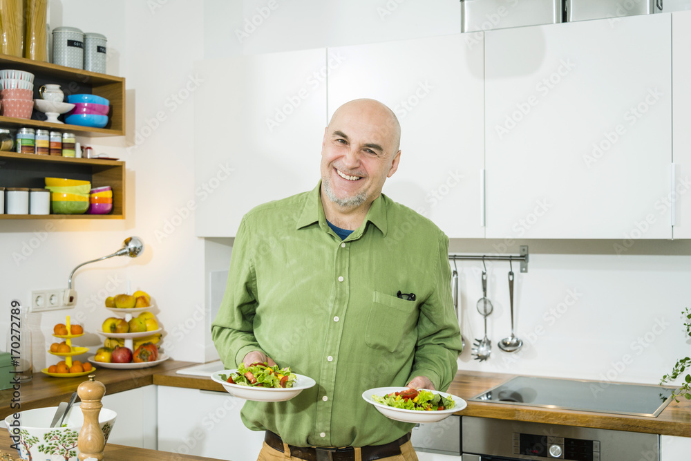 Senior man serving salad Senior man serving salad