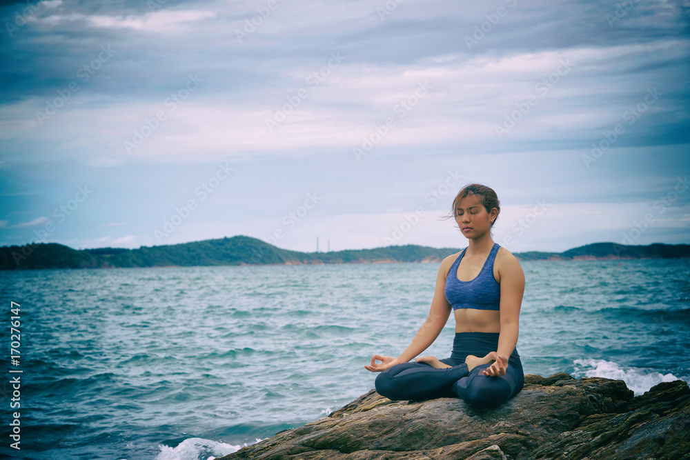 Asian woman yoga and meditation on the sea beach.