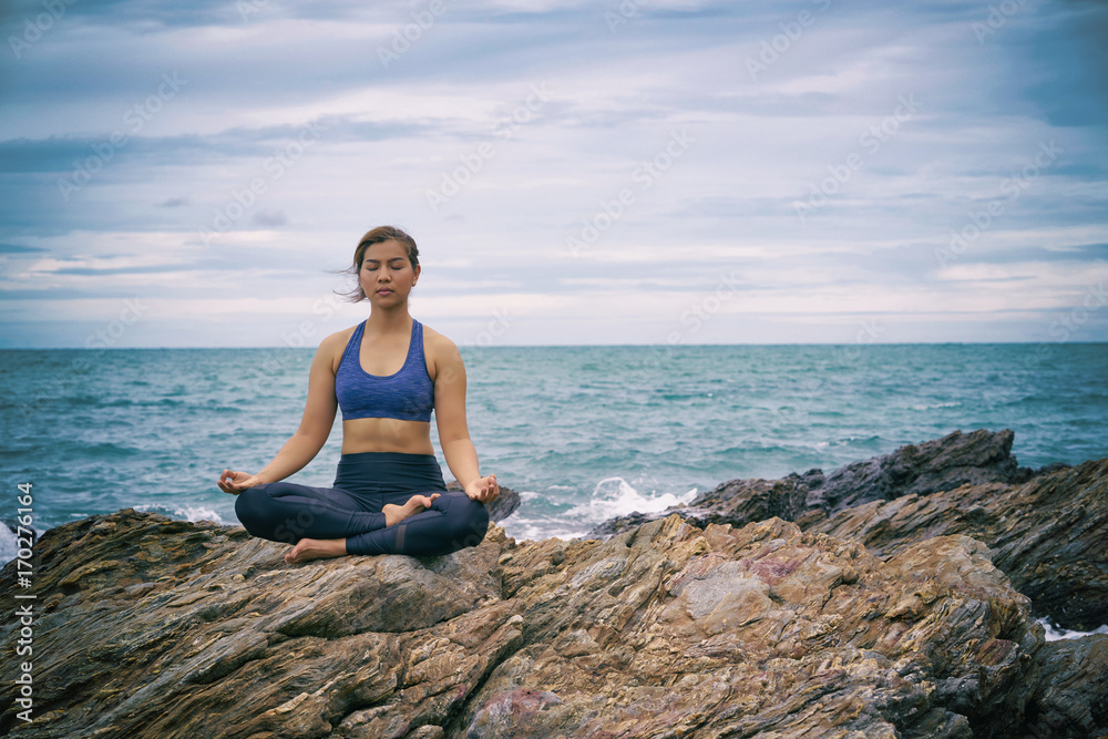 Asian woman yoga and meditation on the sea beach.