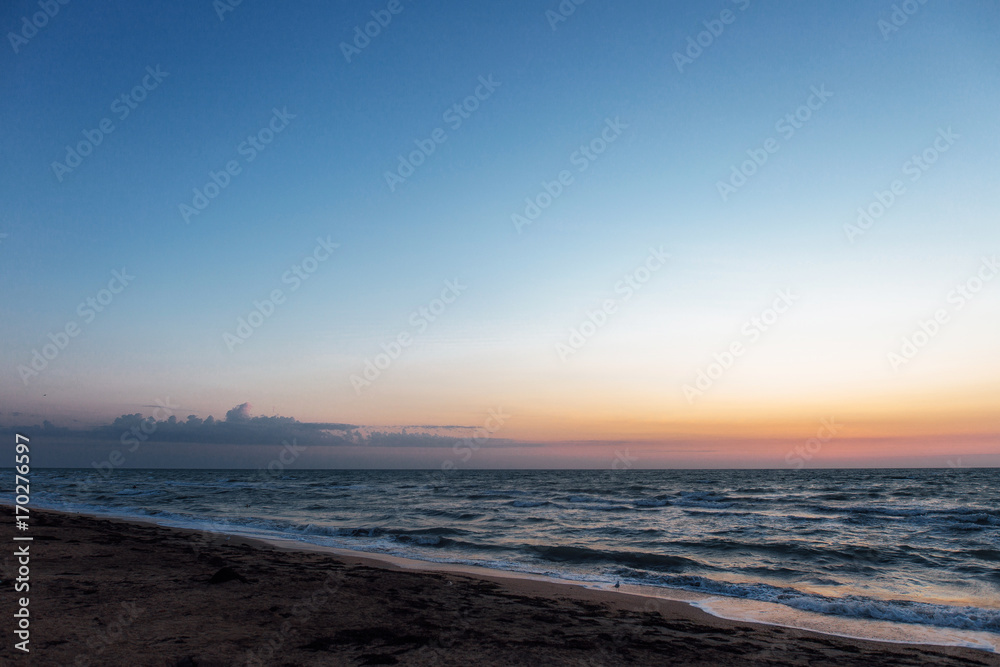 Sunrise near the sea beach with blue waves