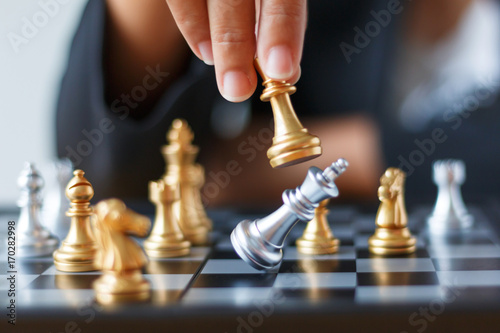 Foto Close up shot hand of business woman moving golden chess to defeat and kill silv