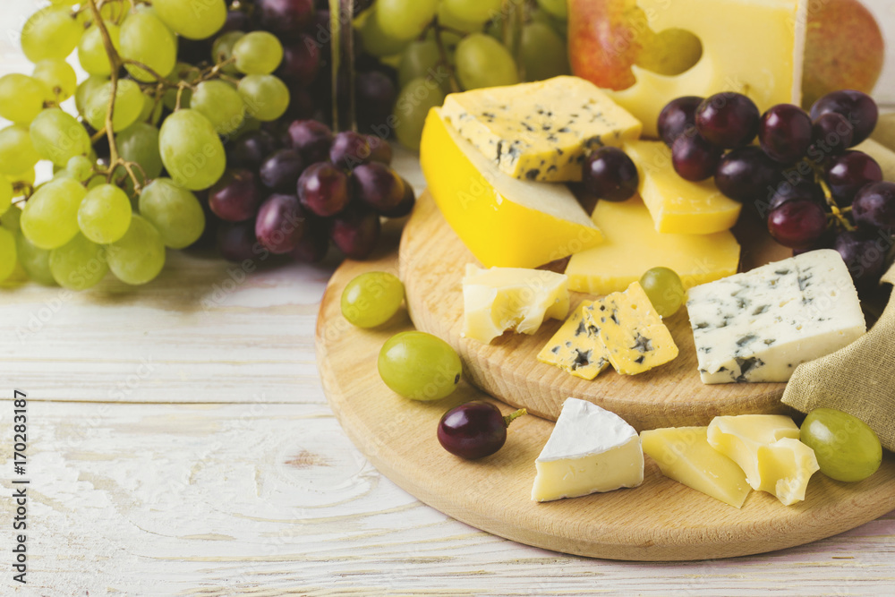 Cheese plate served with wine, fresh grapes and pears Cheese plate served with wine, fresh grapes and pears