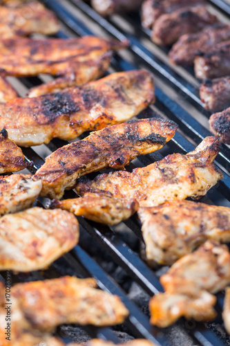 Flat lay above chicken white breast meat on the barbecue grill with kebabs