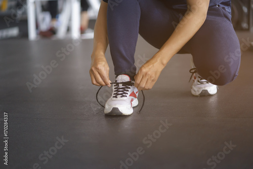 Man tying shoelaces at sneaker in the gym.
