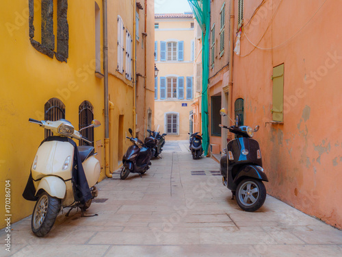 Five scooters in an alley.