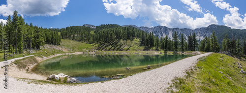 Lake on mountain Petzen with forrest and mountain Hochpetzen in the background photo
