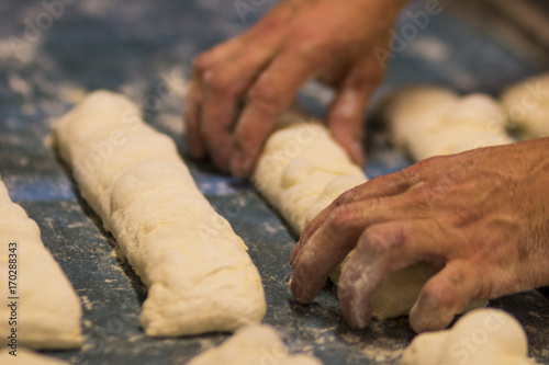 Homem fazendo pão francês em padaria no Brasil foco seletivo