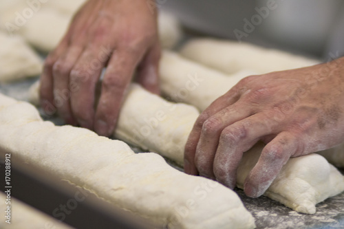 Homem fazendo pão francês em padaria no Brasil foco seletivo photo