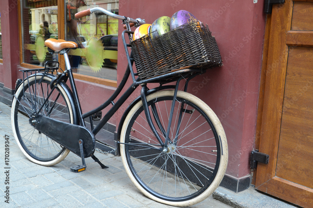 bicycle with basket. Cheese in the basket. Cheese and bike on the street near the building. Old vintage bike
