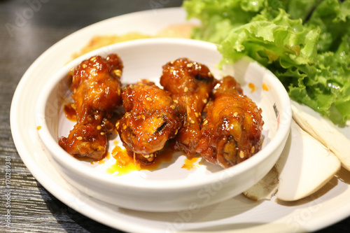 fried drum chicken with spicy sauce on white bowl