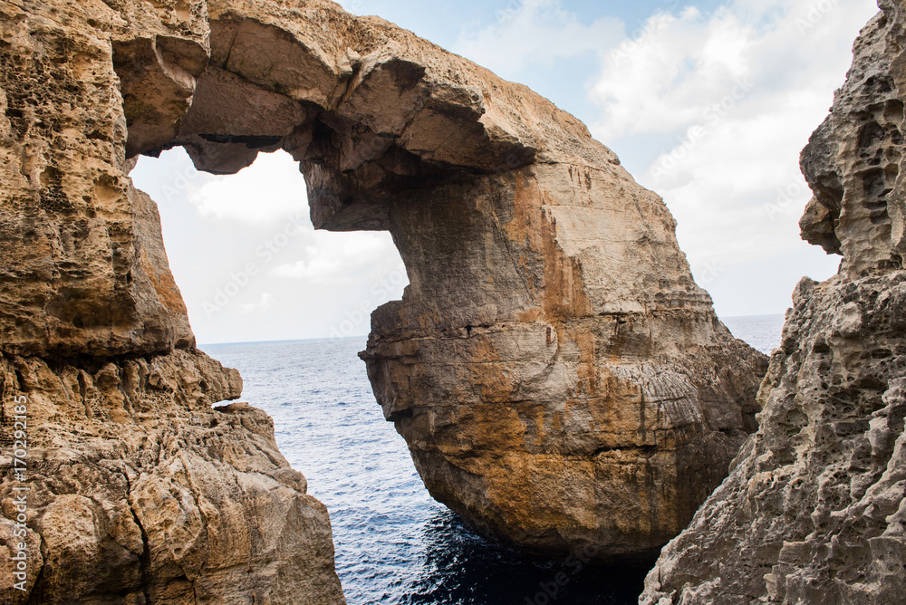Wied il Mielah canyon, natural arch over the sea. Gozo, Malta
