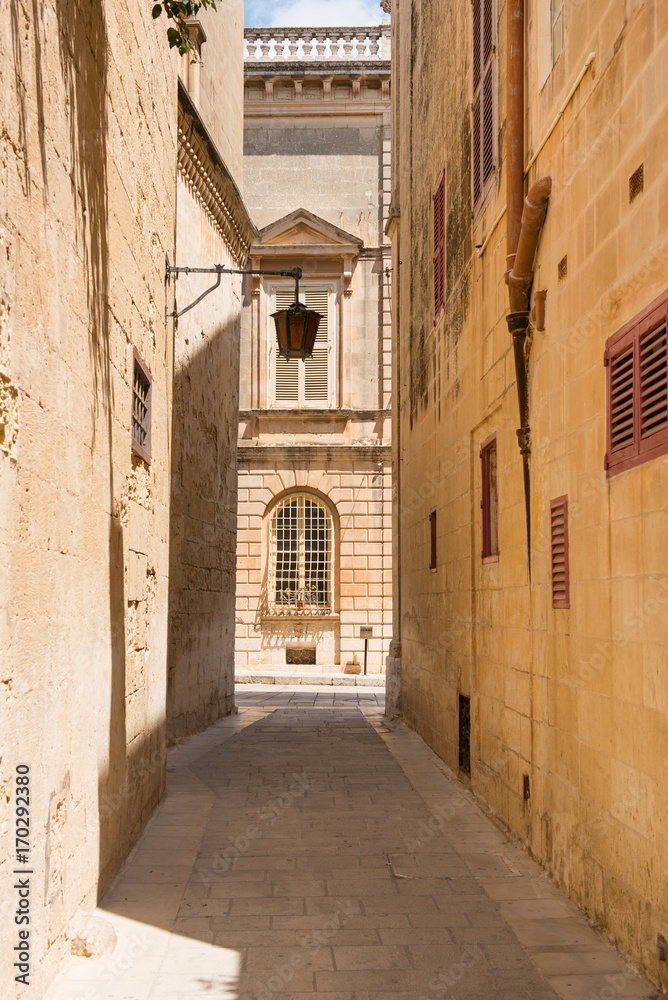 Narrow medieval street with stone houses in Mdina, Malta