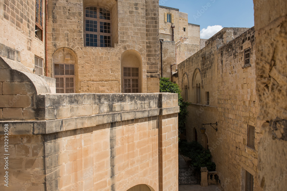 Narrow medieval street with stone houses in Mdina, Malta