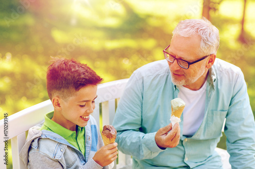old man and boy eating ice cream at summer park