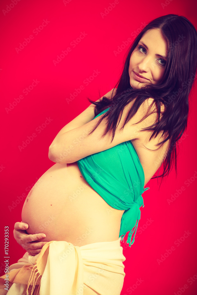 Adult woman showing her pregnant belly Adult woman showing her pregnant belly