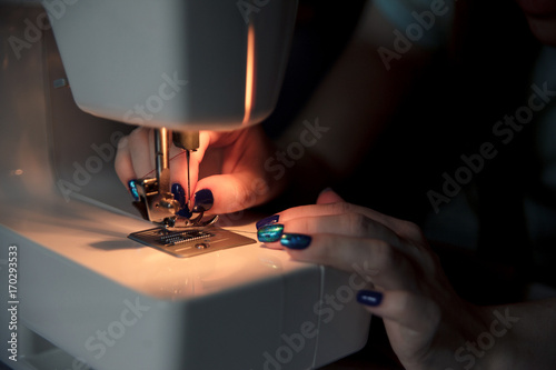 Fototapeta Naklejka Na Ścianę i Meble -  Female hands on sewing machine. Modern sewing process.