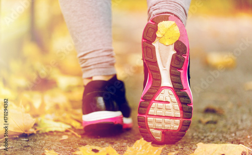 close up of woman feet wearing sneakers in autumn
