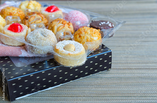 Different Panellets on wooden background. Typical sweets consumed at All Saints Day (Dia Todos Los Santos)  in Catalonia, Spain. Catalan  cakes or cookies made mainly of marzipan rolled in pine nuts. photo