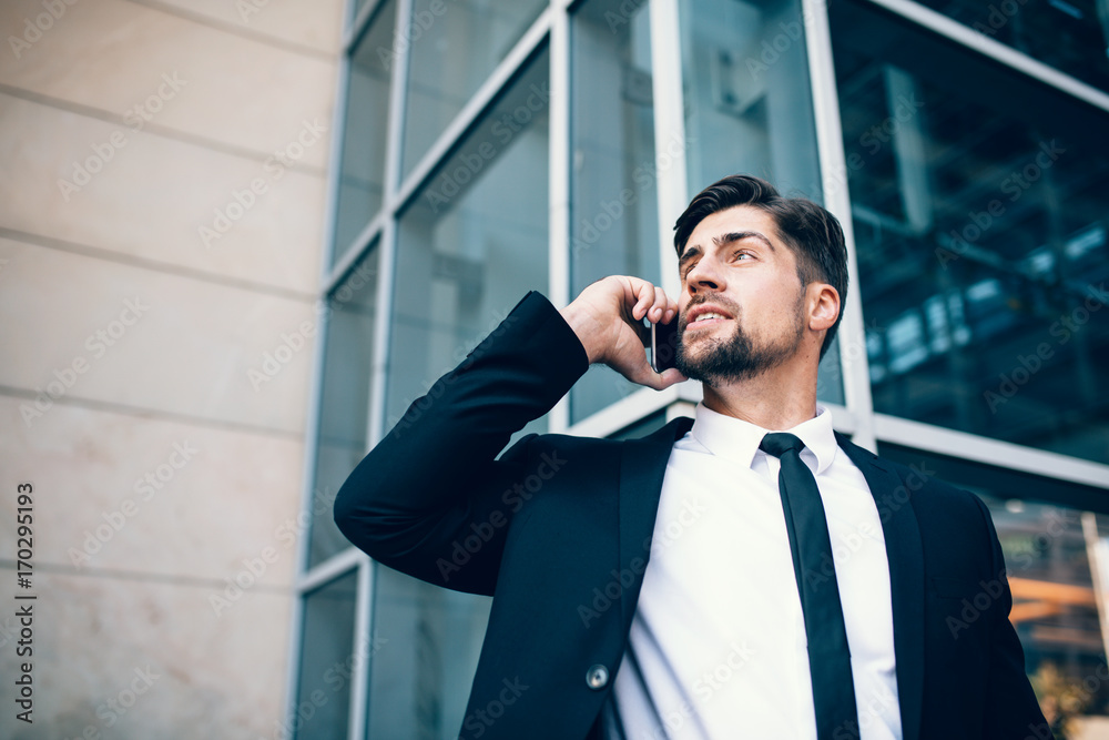 Handsome young man talking on mobile phone and looking away Handsome young man talking on mobile phone and looking away