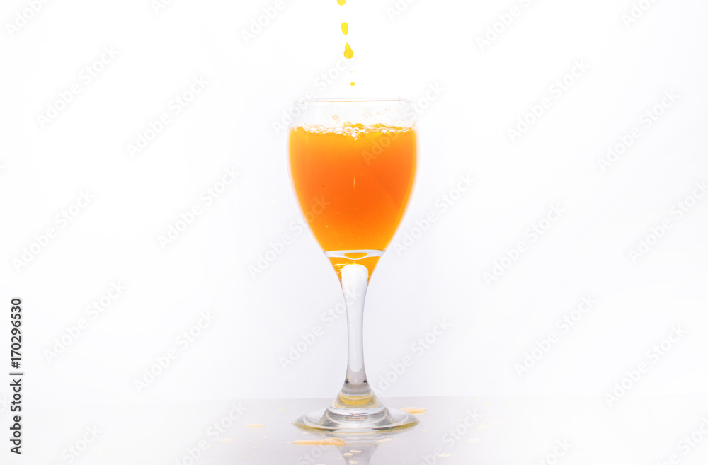 Orange juice splashing out of glass., Isolated white background. Orange juice splashing out of glass., Isolated white background.