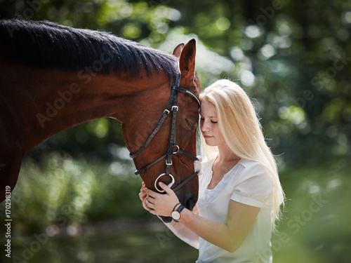 junge blonde Frau mit ihrem Pferd