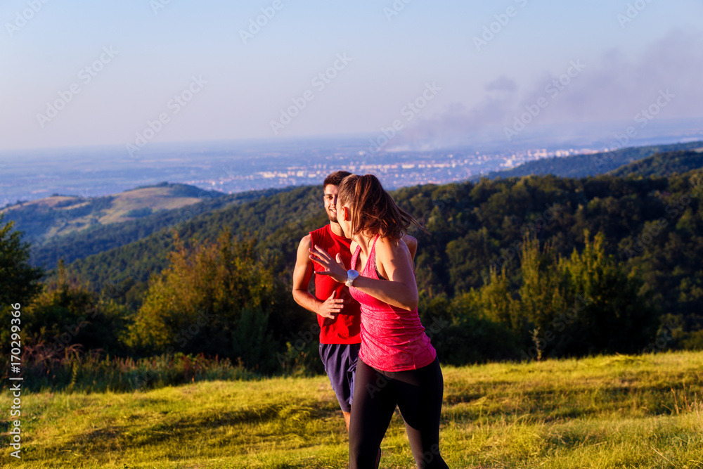 Young couple running in nature on sunset and having fun.