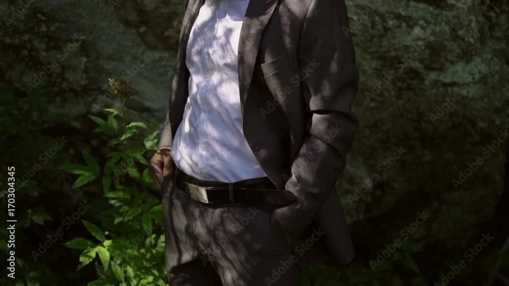 Young caucasian man in classical suit posing near rock Young caucasian man in classical suit posing near rock