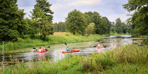 Kayaking on a river among forest and meadows
