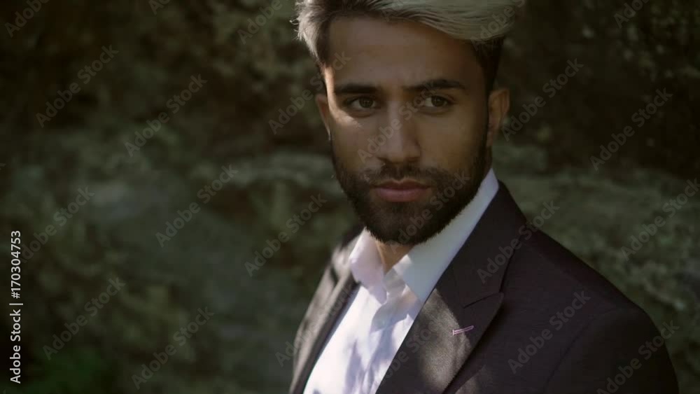 Young caucasian man in classical suit posing near rock Young caucasian man in classical suit posing near rock