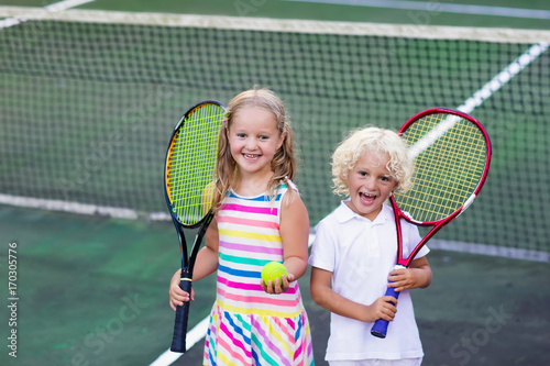 Children playing tennis on outdoor court