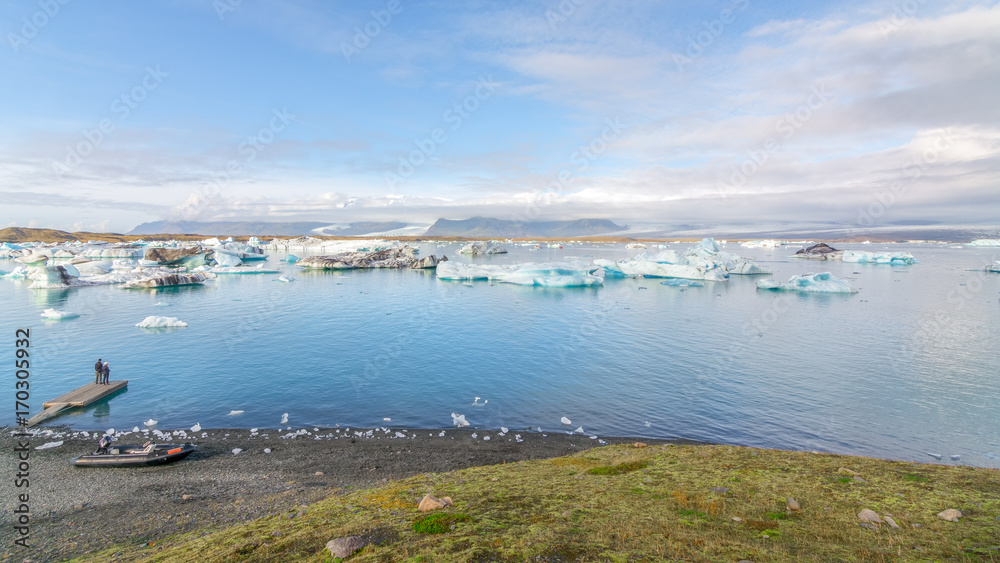 Couple enjoying the wiew of Icebergs in Jokulsarlon glacial lake, Iceland
