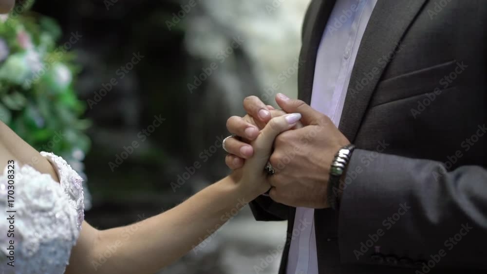 Young wedding couple staying at ceremony near waterfall Young wedding couple staying at ceremony near waterfall