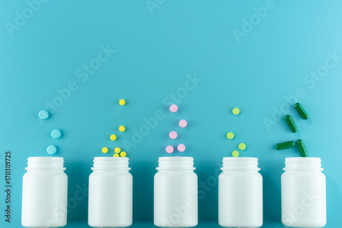 Medicines, supplements and drugs in a bottle on blue background photo