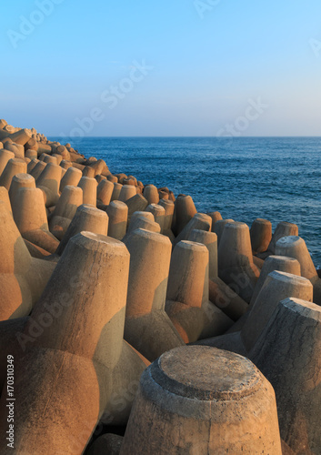 Seascape with concrete tetrapods at sunset