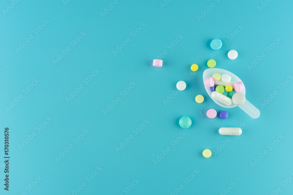 Assorted pharmaceutical medicine pills, tablets and capsules on spoon Assorted pharmaceutical medicine pills, tablets and capsules on spoon