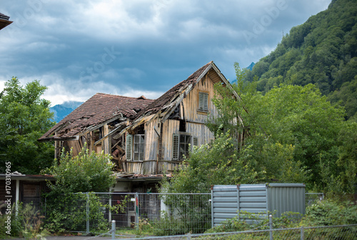 Old broken wooden house and cloudy sky background