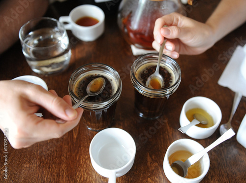 The process of cupping. Tasting freshly brewed coffee with spoons. Coffee accessories on the table