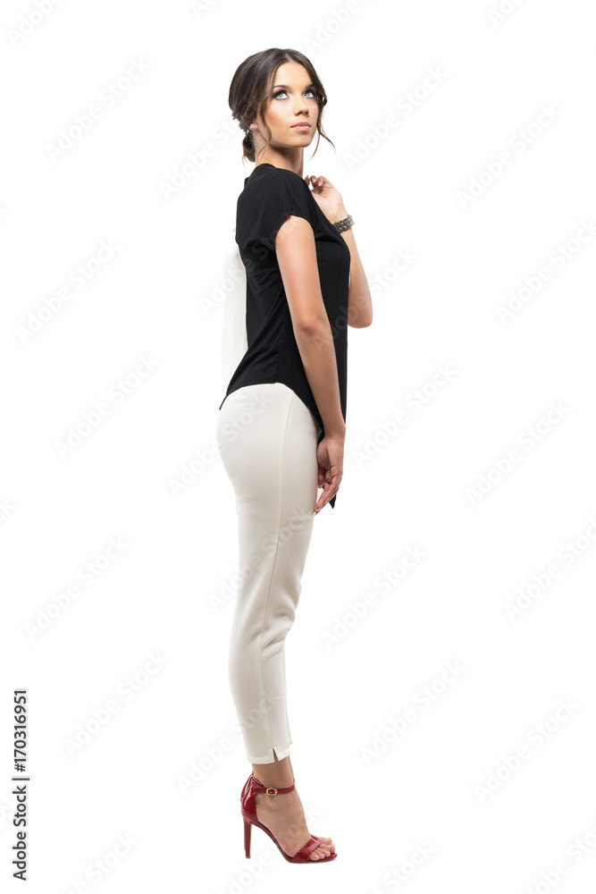 Fototapeta premium Widok z boku eleganckiej kobiety korporacji w garniturze niosącej kurtkę i patrząc zamyślony Portret długość całego ciała na białym tle na tle białego studia