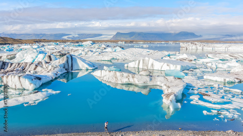 Tourist photographing Icebergs in Jokulsarlon glacial lake, Iceland photo