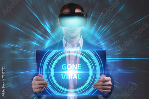 Business, Technology, Internet and network concept. Young businessman working in virtual reality glasses sees the inscription: Gone viral