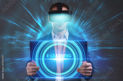 Business, Technology, Internet and network concept. Young businessman working in virtual reality glasses sees the inscription: E-learning