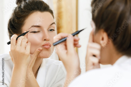 Quadro su tela Woman is disappointed with her skill of applying makeup