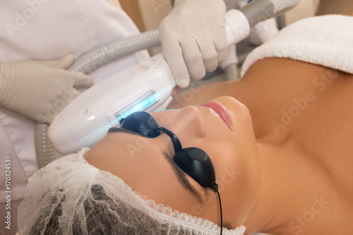 Beautiful woman in beauty salon during photo rejuvenation procedure photo