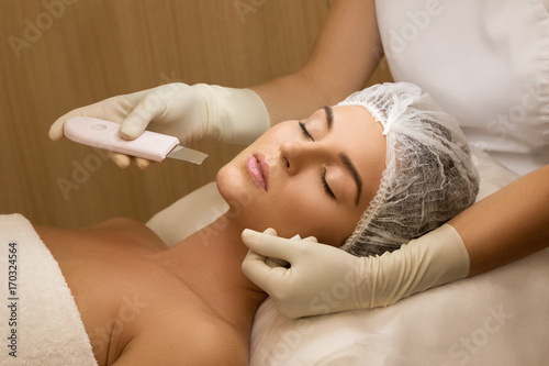 Tableau sur toile Woman during ultrasonic facial cleansing procedure