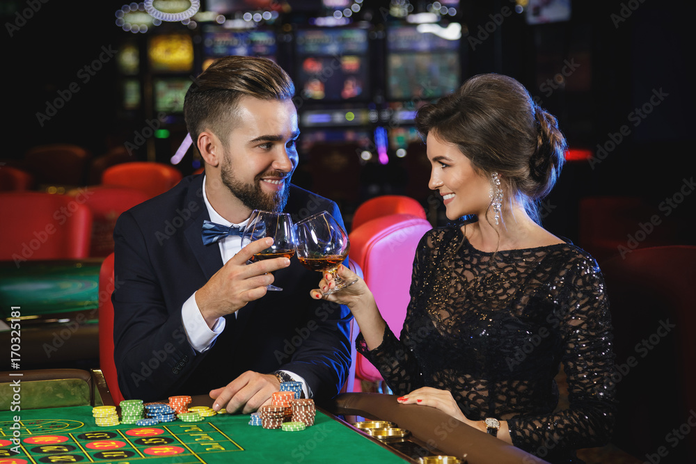 Beautiful and rich couple playing roulette in the casino Beautiful and rich couple playing roulette in the casino