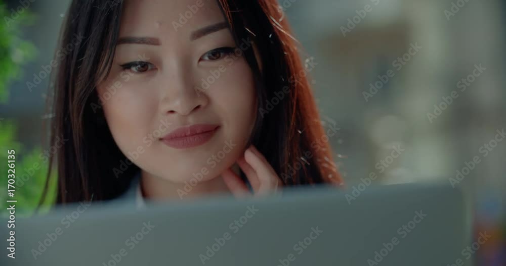 close-up of a beautiful young successful Asian business girl with laptop in summer cafe close-up of a beautiful young successful Asian business girl with laptop in summer cafe