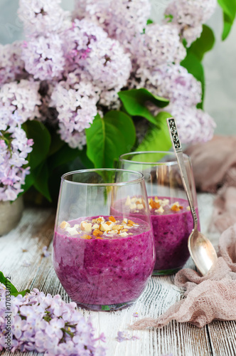 Berry smoothies with oatmeal, lilac flower bouquet
